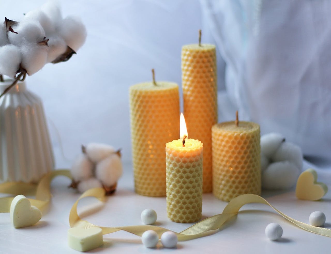 Warm and cozy candlelight scene with aromatic beeswax candles and soft cotton decor, creating a tranquil atmosphere.